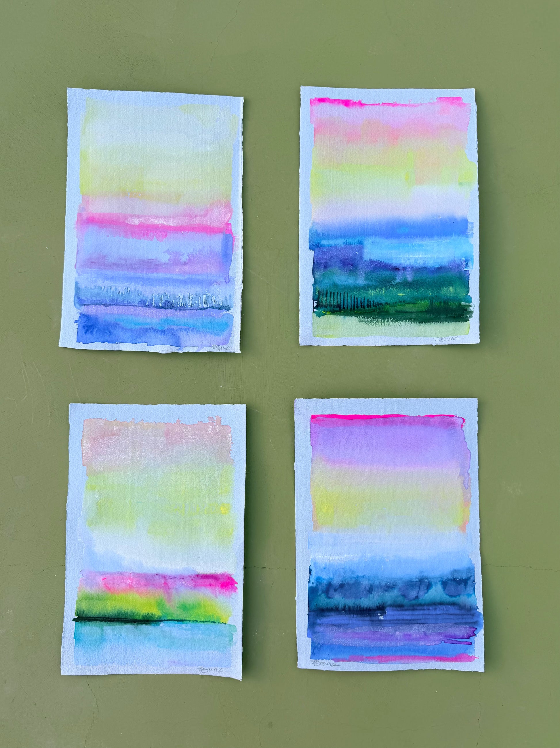 4 luminous seascapes painted on pale blue paper shown against an olive background
