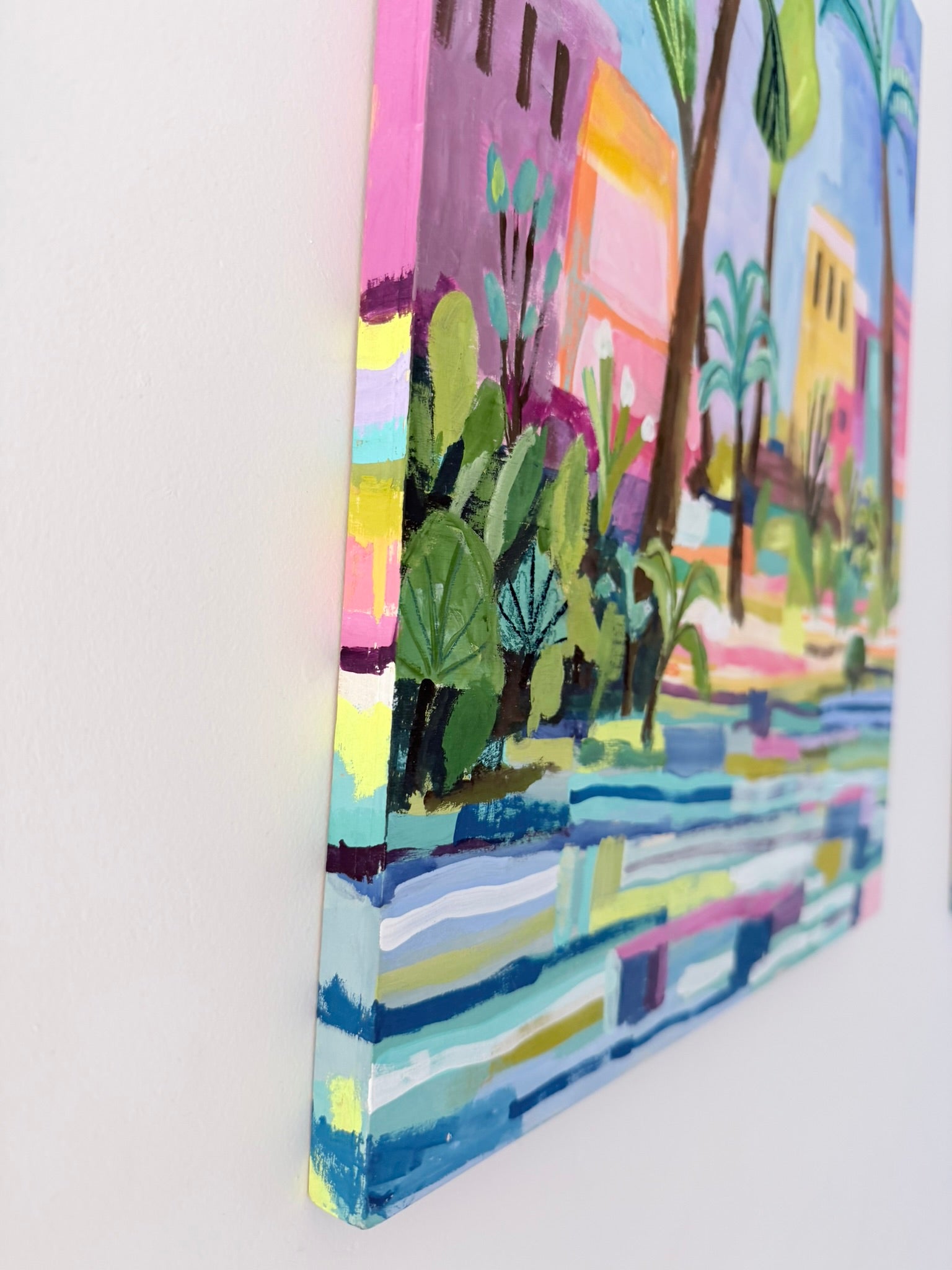 Colorful painting of a tropical scene with palm trees and buildings on a white background