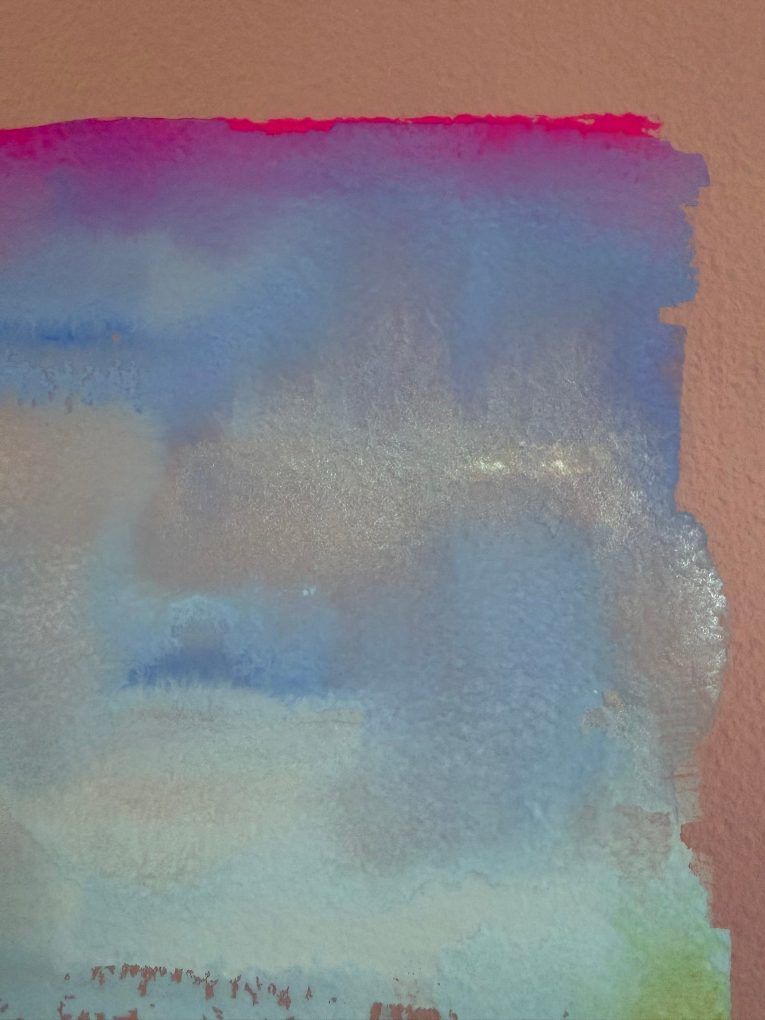 Abstract watercolor painting with blue, pink, and purple hues on a textured surface.