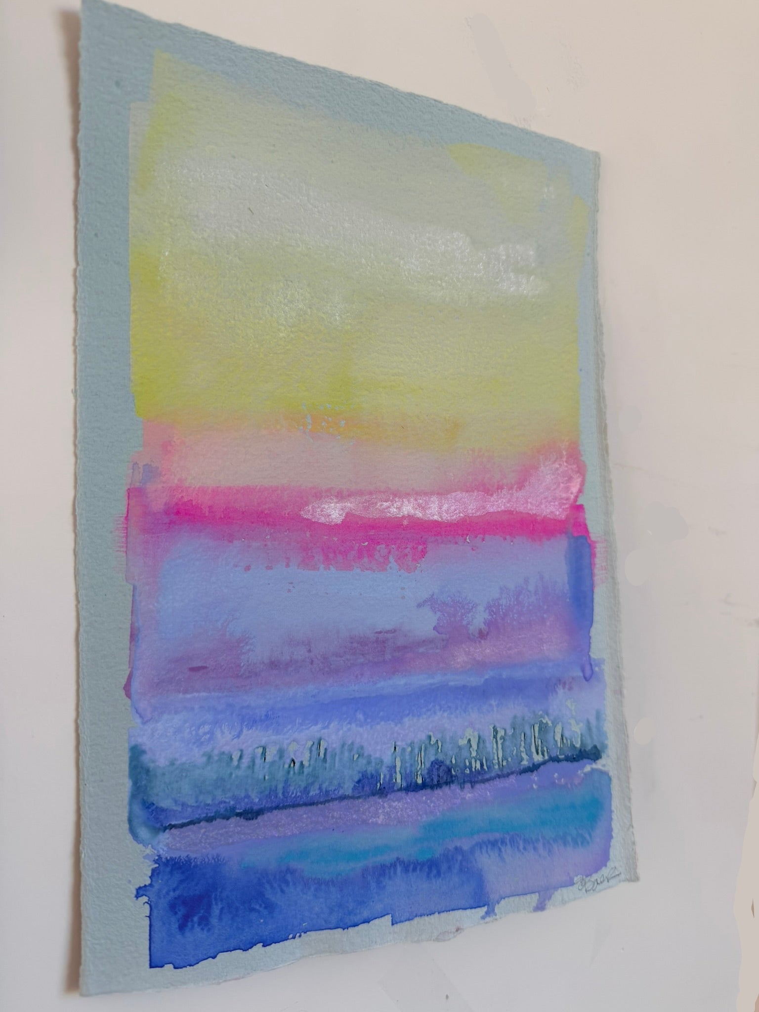 Abstract watercolor painting with horizontal stripes of yellow, pink, and blue on a white background.