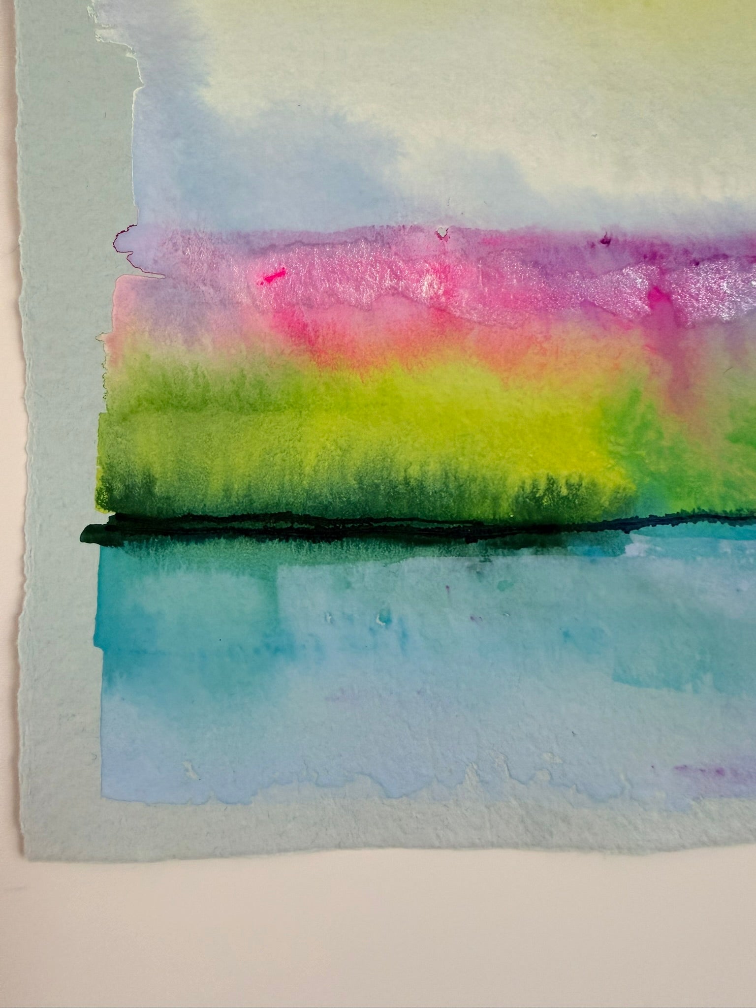 Colorful watercolor painting with a gradient of pink, green, and blue on a white background.