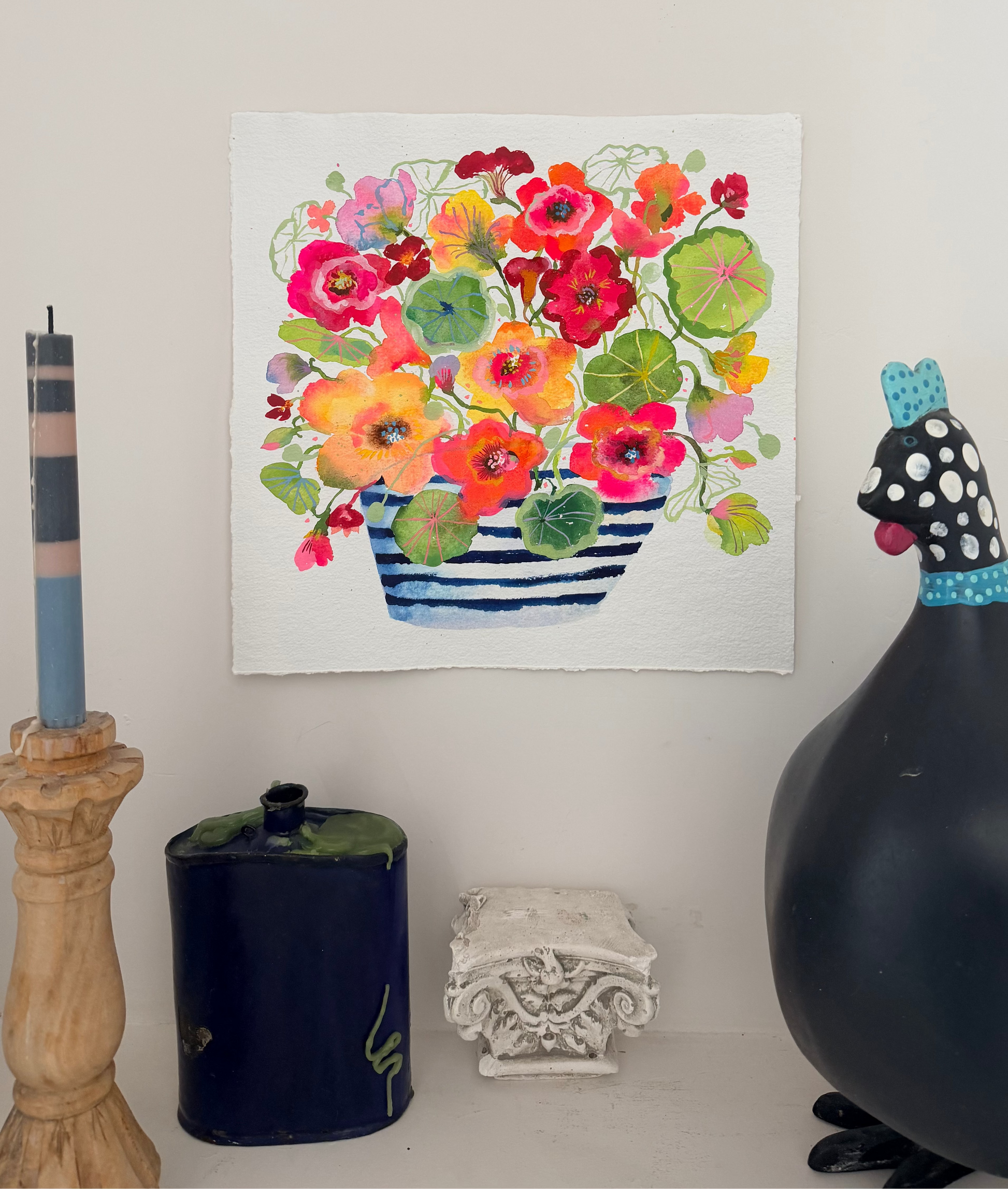 Floral painting on a wall with decorative items below